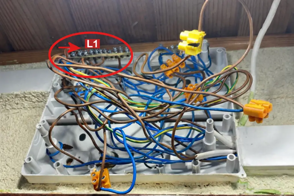 Puszka instalacyjna z chaotycznie połączonymi przewodami elektrycznymi – przykład błędnego wykonania instalacji