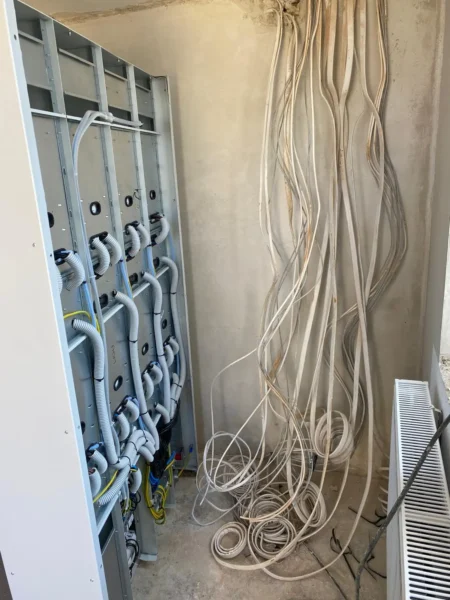 Przewody elektryczne prowadzone do rozdzielnicy w trakcie wykonywania instalacji elektrycznej