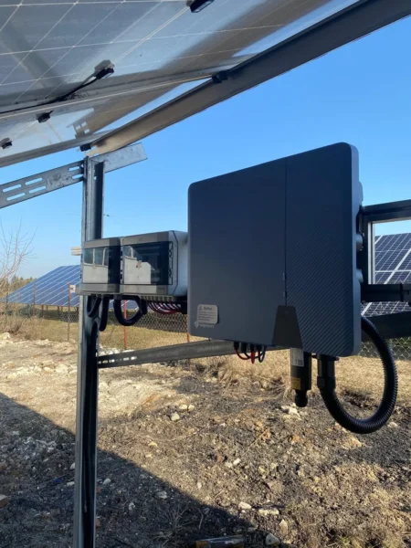 Falownik fotowoltaiczny zamontowany pod konstrukcją paneli PV w instalacji fotowoltaicznej