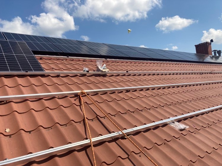 Net-billing w fotowoltaice – jak działa rozliczanie energii w 2024 roku Instalacja fotowoltaiczna na dachu budynku podczas montażu konstrukcji i paneli