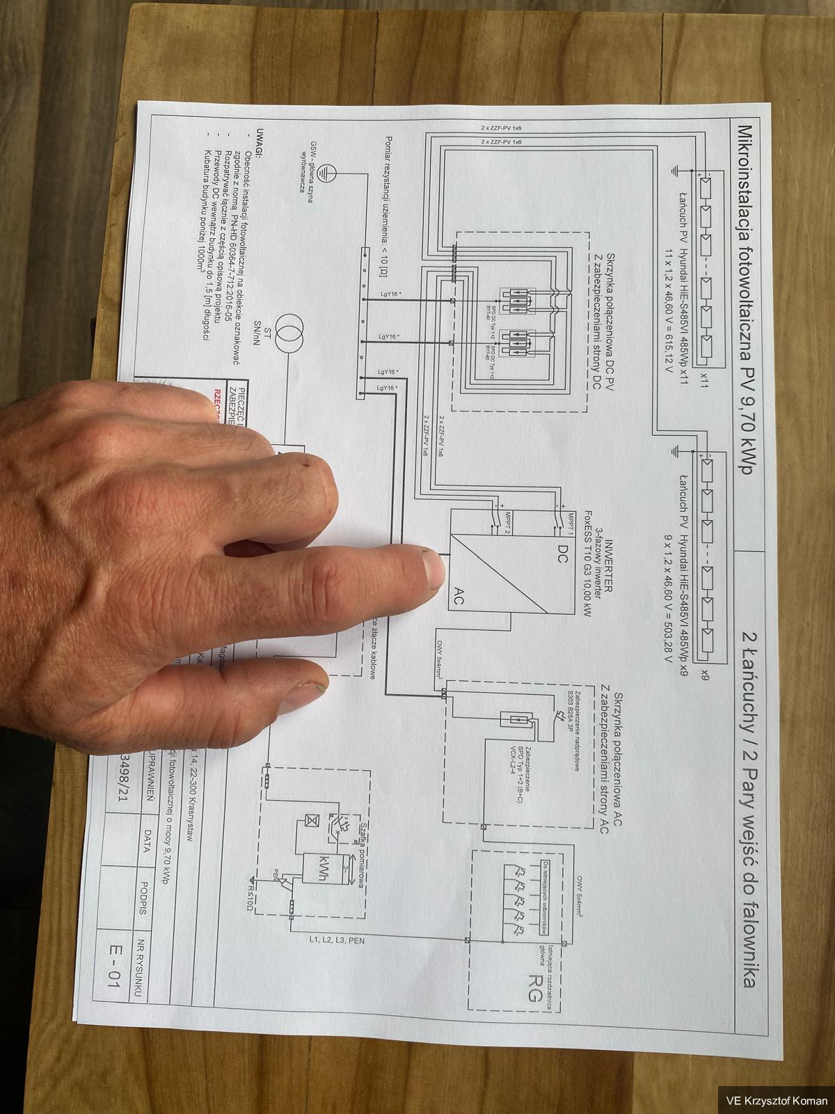 Elektryk pokazuje element na schemacie elektrycznym instalacji fotowoltaicznej